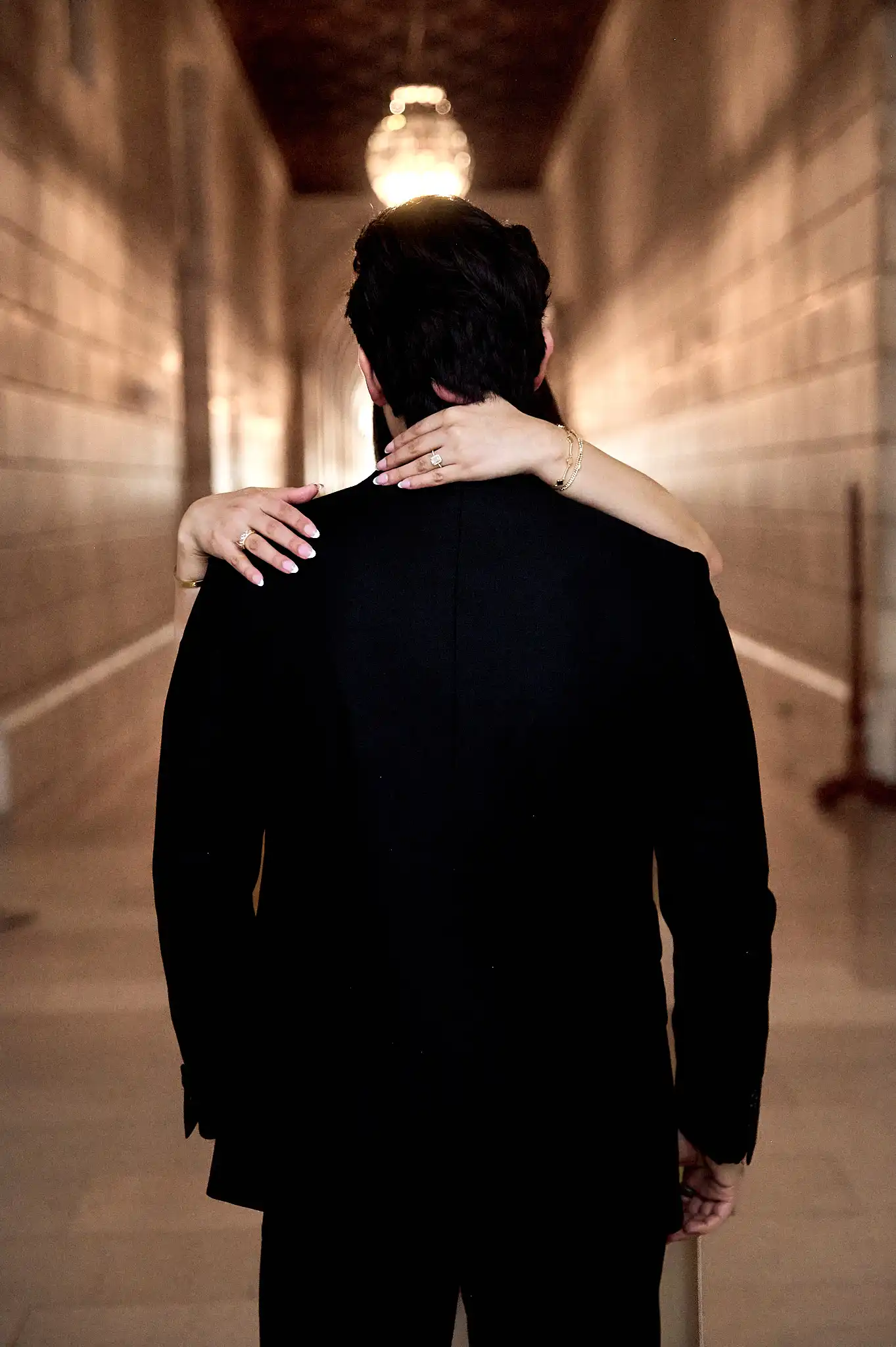 Couple under a marble archway at the New York Public Library, chandelier and oil portrait visible